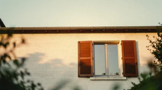 Facade d'une maison francaise avec de grandes fenetres et volets, illustrant le choix eclaire des menuiseries isolantes