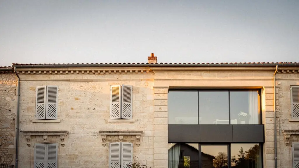 Façade d'une maison de caractère française avec des menuiseries modernes mettant en valeur le patrimoine