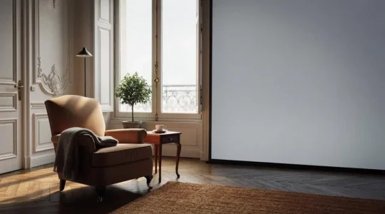 Salon lumineux avec un fauteuil placé près d'une grande baie vitrée, symbolisant un espace de vie reconquis grâce à une meilleure isolation